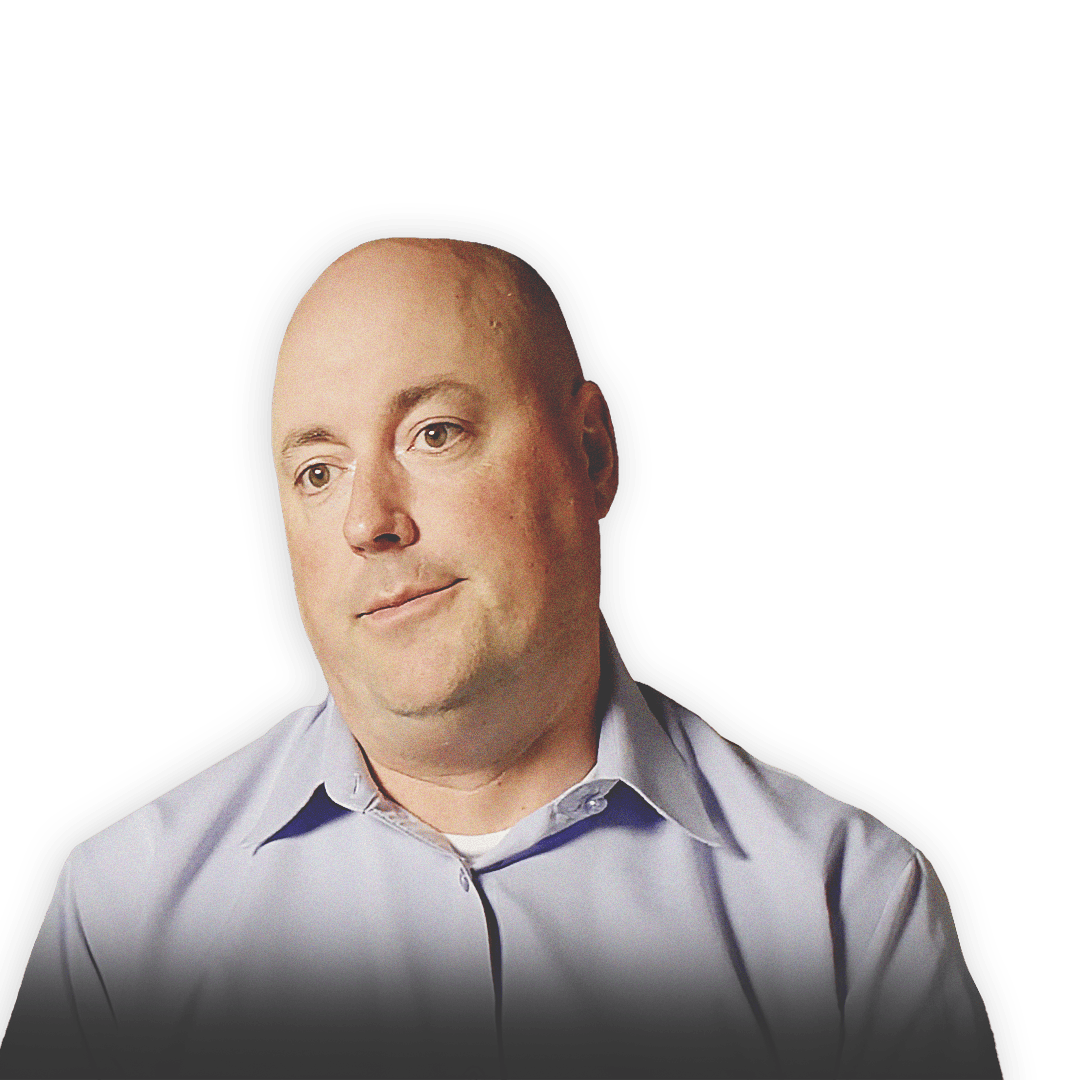 USAID(United States Agency for International development)의 도시 수색구조 팀원인 John Morrison이 지진으로 부서진 건물 배경 앞에 서 있는 이미지