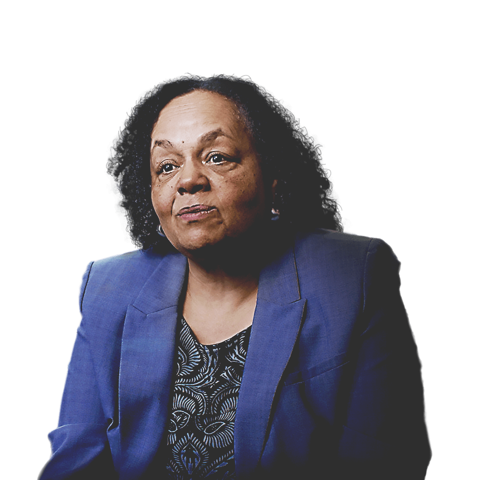 파란색 블레이저를 입고 도시 경관 앞에 앉아 있는 오클랜드 인종 및 평등 책임자 Darlene Flynn