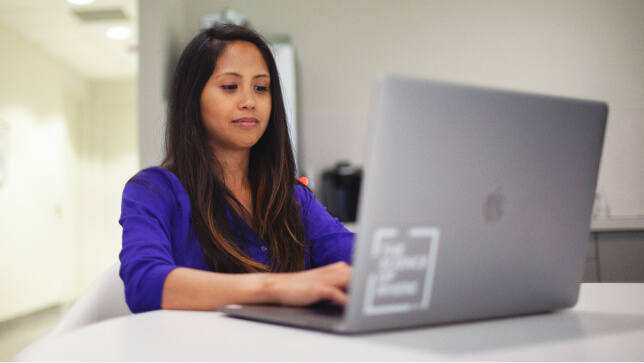 밝은 홈 오피스에서 노트북을 사용하며 웃고 있는 사람