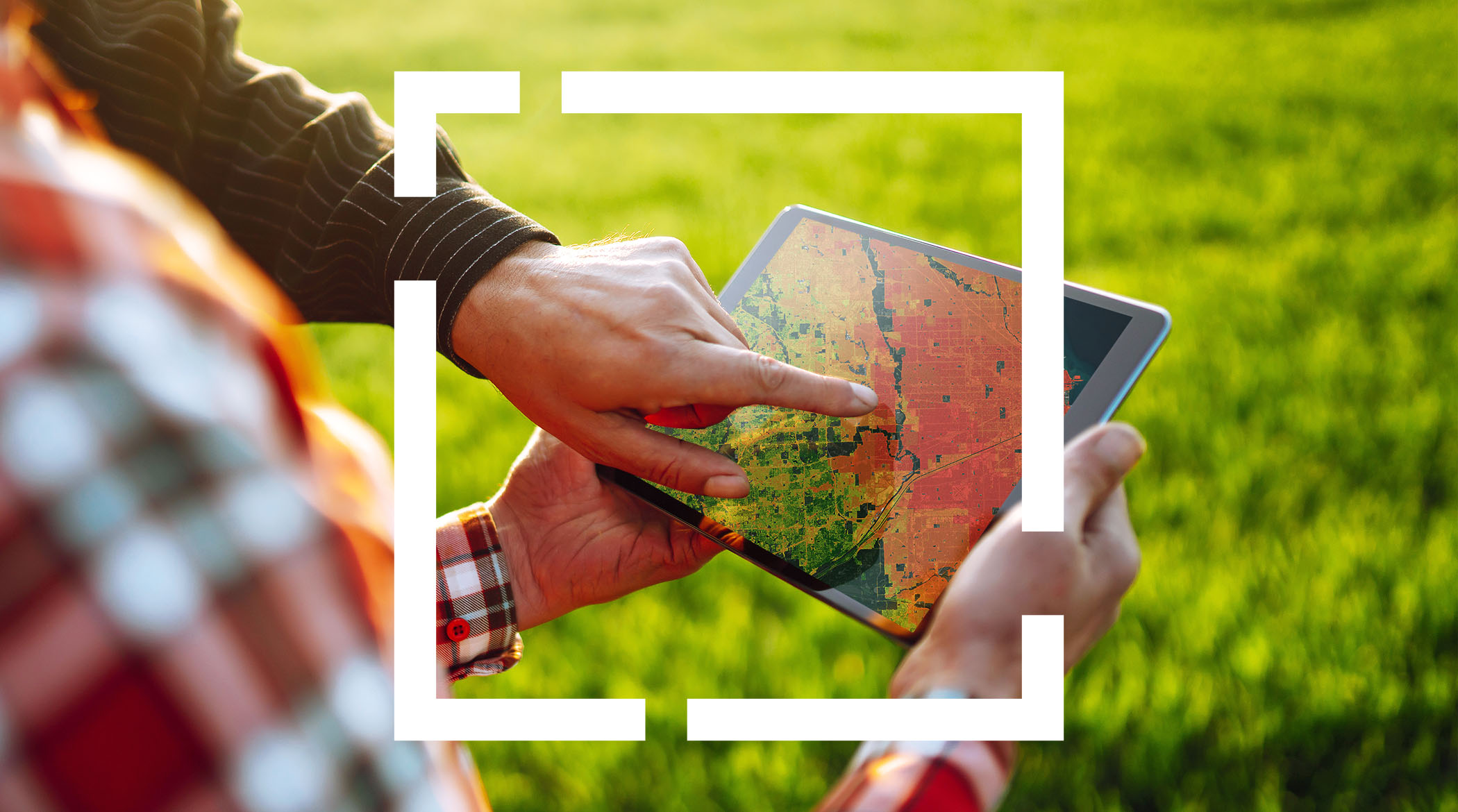 디지털 맵이 있는 태블릿을 손으로 가리키며 야외에 서 있는 두 사람