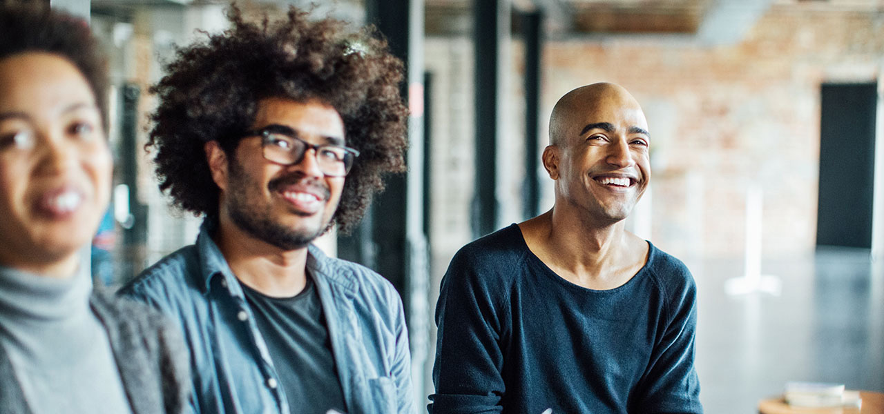 방의 앞쪽으로 시선을 돌리며 앉아 있는 세 사람