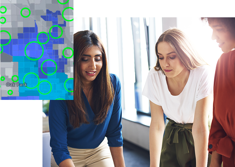 사무실에 서서 전경에 초록색 원으로 표시된 영역을 보여주는 디지털 맵으로 함께 작업 중인 두 사람